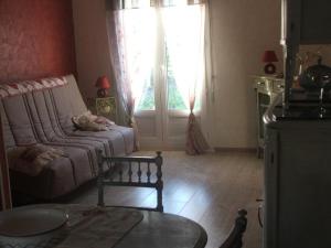 een woonkamer met een bank en een raam bij Gîte confortable près du Zoo de Beauval, avec jardin - FR-1-491-428 in Meusnes +4 foto's