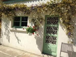 una casa con una puerta verde y una ventana en Gîte Meusnes, 2 pièces, 2 personnes - FR-1-491-428, en Meusnes