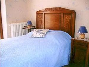 ein Schlafzimmer mit einem Bett mit einem Kopfteil aus Holz und zwei Lampen in der Unterkunft Gîte Bracieux, 4 pièces, 8 personnes - FR-1-491-431 in Bracieux