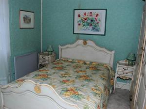 een slaapkamer met een bed met een bloemenbed bij Gîte Huisseau-sur-Cosson, 3 pièces, 4 personnes - FR-1-491-435 in Huisseau-sur-Cosson