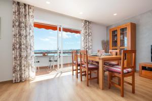 a dining room with a table and chairs and a large window at Apartment Antonia - Alcúdia in Alcudia