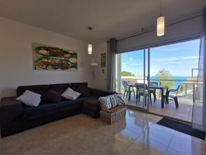 ein Wohnzimmer mit einem Sofa und einem Tisch sowie einem Balkon in der Unterkunft Apartamento Llançà, 2 dormitorios, 4 personas - ES-89-137 in Llança