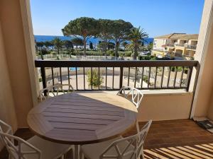 a table on a balcony with a view of the ocean at Appartement T2 avec piscine et vue mer proche plages - FR-1-768-76 in Les Issambres