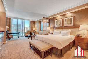 a bedroom with a large bed and a living room at MGM Signature-23-811 F1 Track & Strip View Studio in Las Vegas
