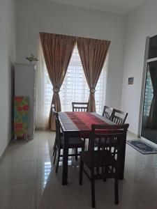 una sala da pranzo con tavolo, sedie e finestra di Live Well Homestay Senawang a Seremban