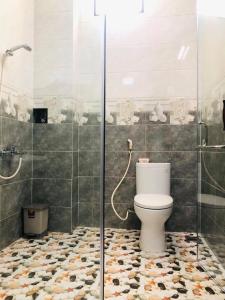 a bathroom with a toilet and a glass shower at KHÁCH SẠN ĐẾ VƯƠNG in Cao Lãnh