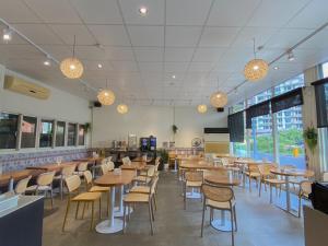 a restaurant with wooden tables and chairs and windows at Ashare Hotel in Jiaoxi