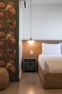 ein Schlafzimmer mit einem Bett und einer Wand mit Blumentapete in der Unterkunft Best Bet Motor Lodge in Reno