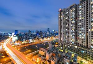 een skyline van de stad 's nachts met verkeer en gebouwen bij Kandy in Rivergate Luxury Apartment - near Ben Thanh market in Ho Chi Minh-stad
