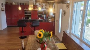 eine Küche mit einem Tisch und einer Vase aus Sonnenblumen in der Unterkunft Casa Makatea - b44831 in Brione sopra Minusio
