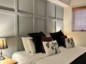 1 dormitorio con 1 cama blanca grande con almohadas en Villa Sorelle en Daylesford