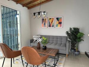 a living room with a couch and a table and chairs at CASA ARKADIA MEDELLÍN in Medellín