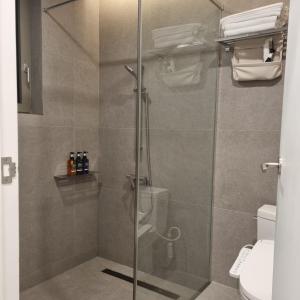 a shower with a glass door in a bathroom at Laon on 37 in Tongyeong