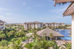 ein Luftblick auf ein Resort mit einem Pool und Palmen in der Unterkunft Vg Sun Condominio pe na areia estilo resort in Caucaia