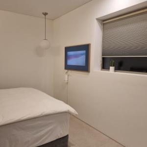 a bedroom with a bed and a flat screen tv at Laon on 37 in Tongyeong
