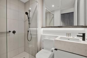 a bathroom with a shower and a toilet and a sink at Sophisticated 2-Bed by St Kilda Botanical Gardens in Melbourne