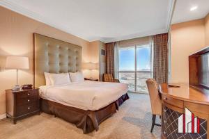 Dormitorio con cama, escritorio y TV en MGM Signature-28-814 1Br 2Ba F1 Pits View Balcony, en Las Vegas