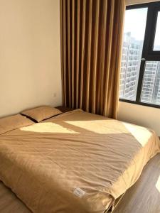 ein Bett in einem Schlafzimmer mit einem großen Fenster in der Unterkunft 2BR Vinhomes Apartment! A sun-drenched apartment in Hanoi
