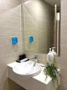 ein Badezimmer mit einem weißen Waschbecken und einem Spiegel in der Unterkunft 2BR Vinhomes Apartment! A sun-drenched apartment in Hanoi