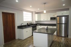 a kitchen with white cabinets and a stainless steel refrigerator at Modern 2-bedroom, 2 bath unit close to Embassies in Georgetown