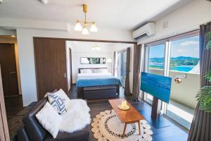 un salon avec un lit et un canapé dans l'établissement オーシャンテラス瀬底303, à Ufugumui 40 autres photos