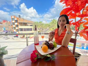 eine Frau sitzt an einem Tisch mit einem Teller Obst in der Unterkunft Irigoin Hospedaje in Nueva Cajamarca