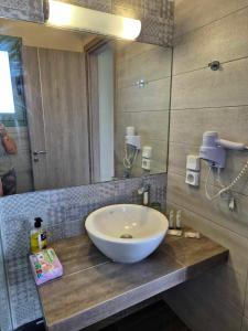 een badkamer met een wastafel en een spiegel bij HELEN aparment in Argostoli