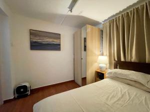um quarto com uma cama branca e uma janela em ChillOut in Cheung Chau em Hong Kong