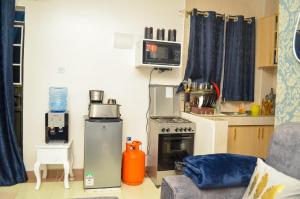 een woonkamer met een keuken met een fornuis bij Air BnB Holiday Rooms in Nairobi