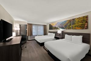 ein Hotelzimmer mit 2 Betten und einem Flachbild-TV in der Unterkunft Clarion Pointe Rhinelander Downtown in Rhinelander