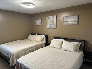 1 dormitorio con 2 camas y 2 cuadros en la pared en Retreat to my Contemporary Home, en Morgantown