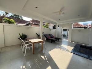 a patio with a table and chairs and a couch at VIEW TALAY VILLA POOL HOUSE 285 in Jomtien Beach