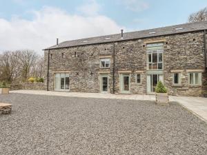 ein altes Steingebäude mit einer Bank davor in der Unterkunft Oak Cottage in Ulverston