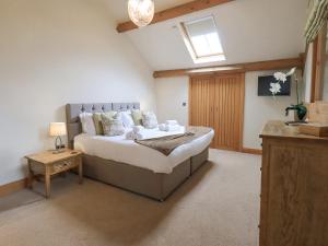 een slaapkamer met een groot bed en een tafel bij Oak Cottage in Ulverston