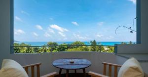 balcón con mesa y vistas al océano en Seychelles en Anse Boileau