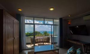 Anse Boileau的住宿－Seychelles，客房设有桌椅和大窗户。