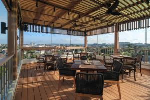 Un restaurante con mesas y sillas en un balcón. en The Margaux Hotel Yogyakarta, en Yogyakarta