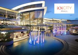 a large building with a fountain in front of it at Apartment Near IOI Resort City Shopping Mall Serdang Putrajaya in Putrajaya