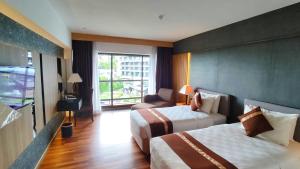 a hotel room with two beds and a window at Batam View Beach Resort in Nongsa