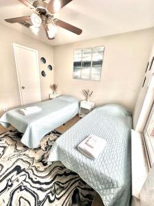 a bedroom with two beds and a ceiling fan at A Blissful Townhome with a Game Room Near AT&T Stadium, Six Flags, DFW Airport in Arlington