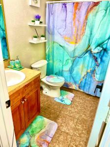 a bathroom with a toilet and a shower curtain at A Blissful Townhome with a Game Room Near AT&T Stadium, Six Flags, DFW Airport in Arlington