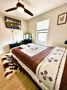 a bedroom with a large bed and a ceiling fan at A Blissful Townhome with a Game Room Near AT&T Stadium, Six Flags, DFW Airport in Arlington