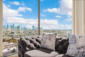 uma sala de estar com um sofá e uma grande janela em Beautiful 2 BR Sky View Apartment em Los Angeles