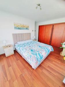 - une chambre avec un grand lit et du parquet dans l'établissement Nautilus, Departamento Hermosa Ubicacion Frente al Mar Piso 30, à Iquique