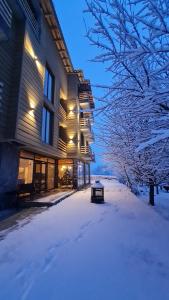 un edificio con la neve sul terreno di fronte di Mestia Roots a Mestia