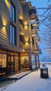 un edificio con la neve sul terreno di fronte di Mestia Roots a Mestia