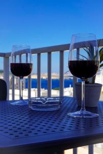 dois copos de vinho tinto sentados numa mesa em Centrally located, well equipped, stylish flat. em St. Paul's Bay