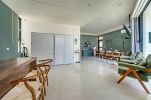 a kitchen and living room with a couch and chairs at 澎湖笑掌家 in Magong