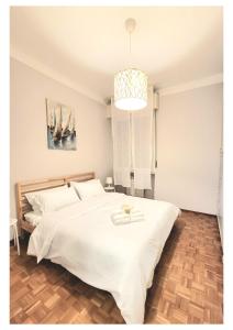 a bedroom with a large white bed and a chandelier at Sail Away Camogli in Camogli
