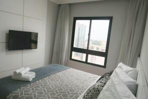a bedroom with a bed and a tv and a window at Lunare Hotel Pinheiros in Sao Paulo